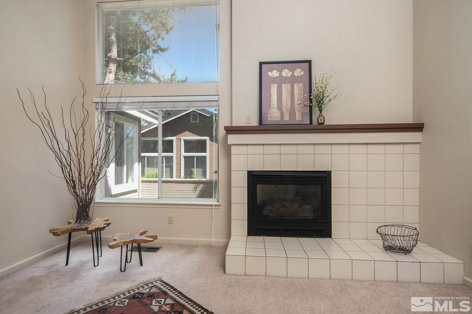 3335 Spring Creek Circle Reno, NV 89509 - Photo 4 of 30 a living room with furniture a fireplace and a painting