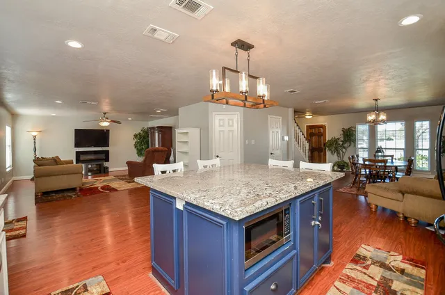 a kitchen with stainless steel appliances granite countertop a dining table chairs stove a sink and dishwasher