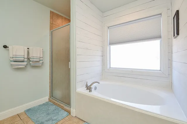 a bathroom with a tub sink and mirror
