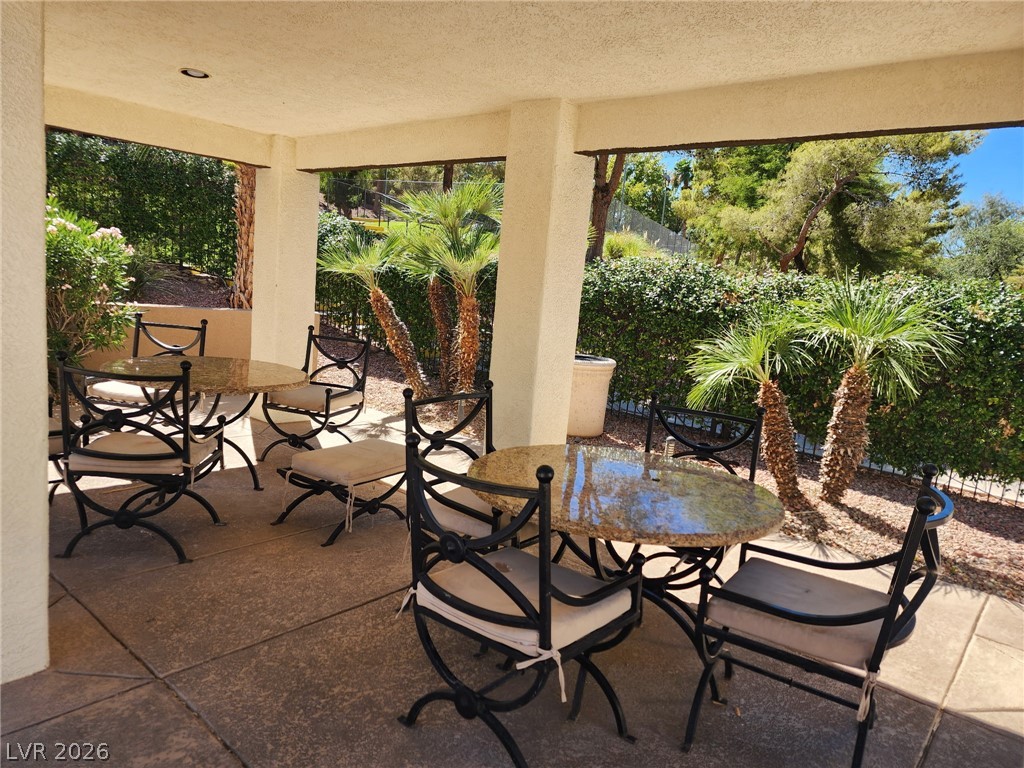 231 West Horizon Ridge Parkway, Unit 1127 Henderson, NV 89012 - Photo 14 of 39 An inviting covered patio offers an ideal spot for outdoor enjoyment, overlooking manicured greenery.