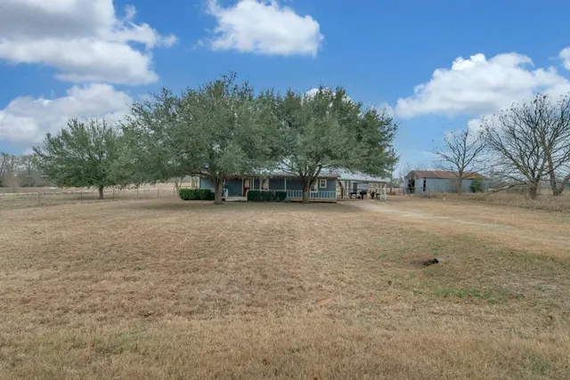 a view of a field with trees in the background