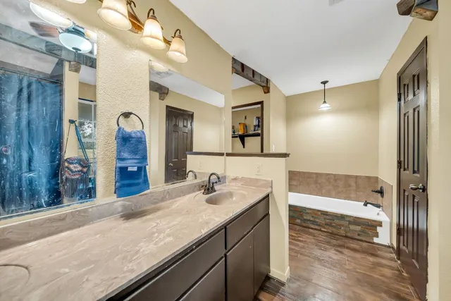 a bathroom with a granite countertop sink a mirror and a shower