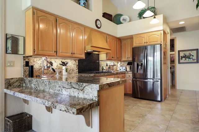 a kitchen with stainless steel appliances granite countertop a refrigerator sink and cabinets