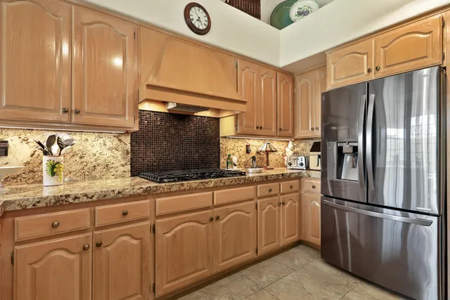 a kitchen with granite countertop white cabinets stainless steel appliances and a sink