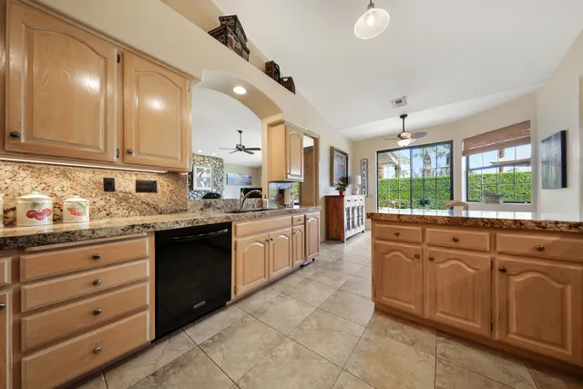 a kitchen with granite countertop stainless steel appliances and refrigerator