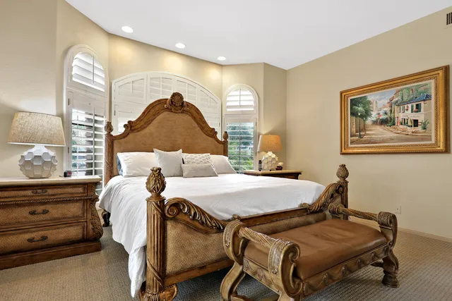 a large white bathroom with a large mirror vanity and a bathtub