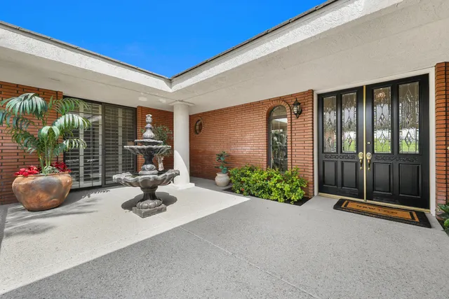 a front view of a house with potted plants