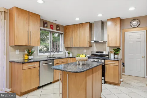 a kitchen with stainless steel appliances granite countertop a stove a sink dishwasher and a refrigerator