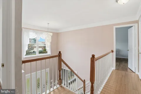 a view of a hallway with wooden floor and windows