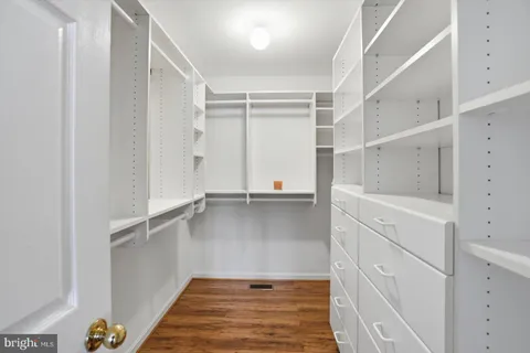 a view of walk in closet with empty racks