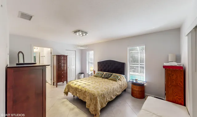 a bedroom with a bed and a chandelier