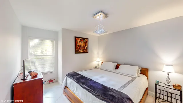 a bedroom with a bed and a chandelier