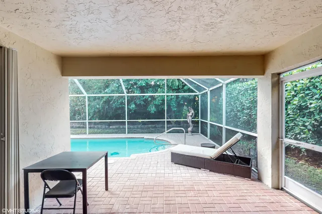 an aerial view of a house with a swimming pool and outdoor seating