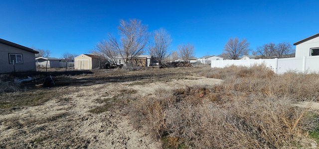 230 Maple Street, Unit 27 Wellington, UT 84542 - Photo 2 of 9 View of yard featuring a storage unit and a residential view