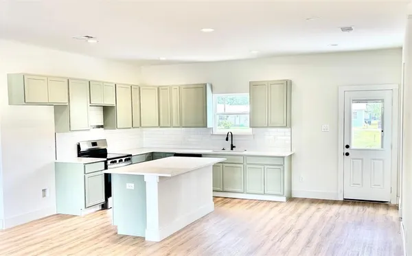 a kitchen with a stove a sink and a refrigerator