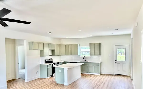 a kitchen with a sink and wooden floor