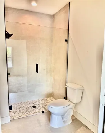 a bathroom with a toilet and a shower