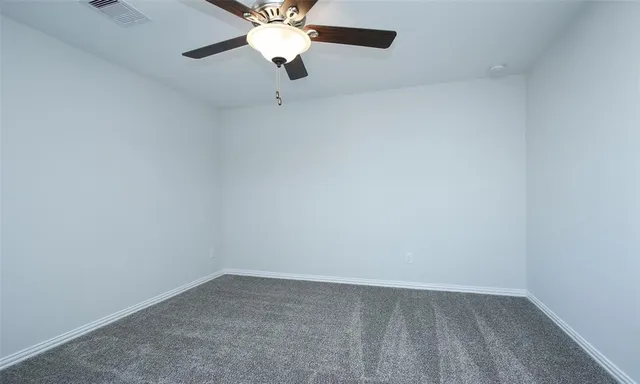 an empty room with a chandelier fan