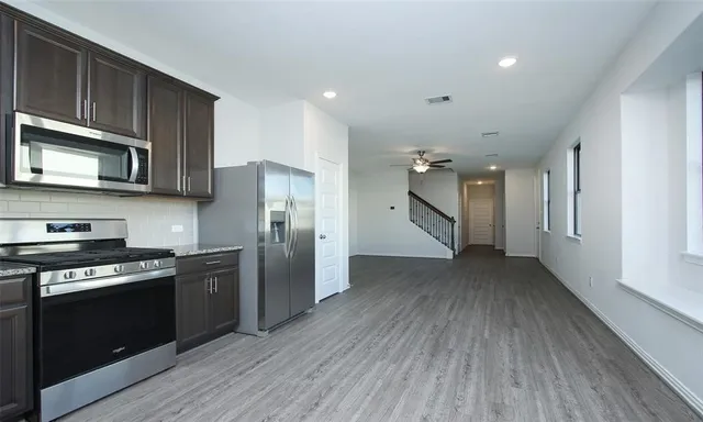 a kitchen with stainless steel appliances granite countertop a stove a refrigerator and a microwave