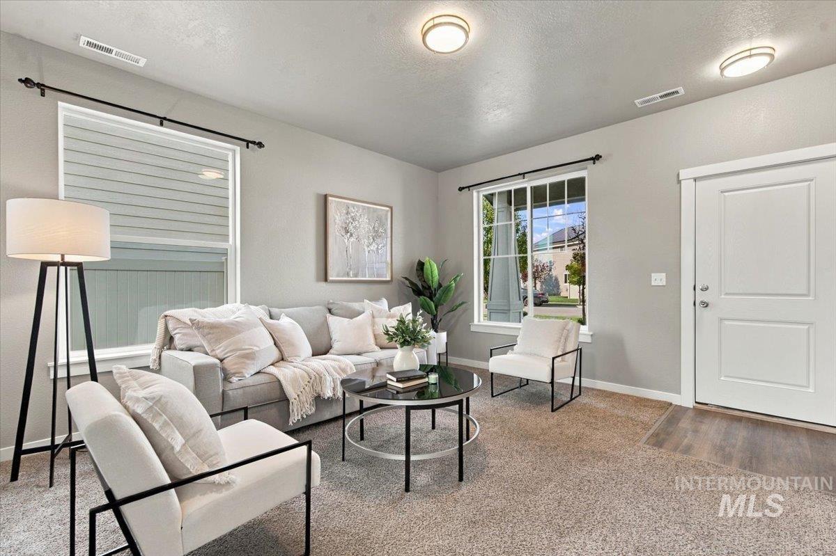 124 South Sunset Point Way Meridian, ID 83642 - Photo 5 of 24 Carpeted living area with light gray walls, white trim, and recessed lighting