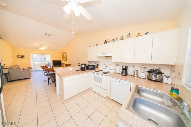 a large white kitchen with cabinets