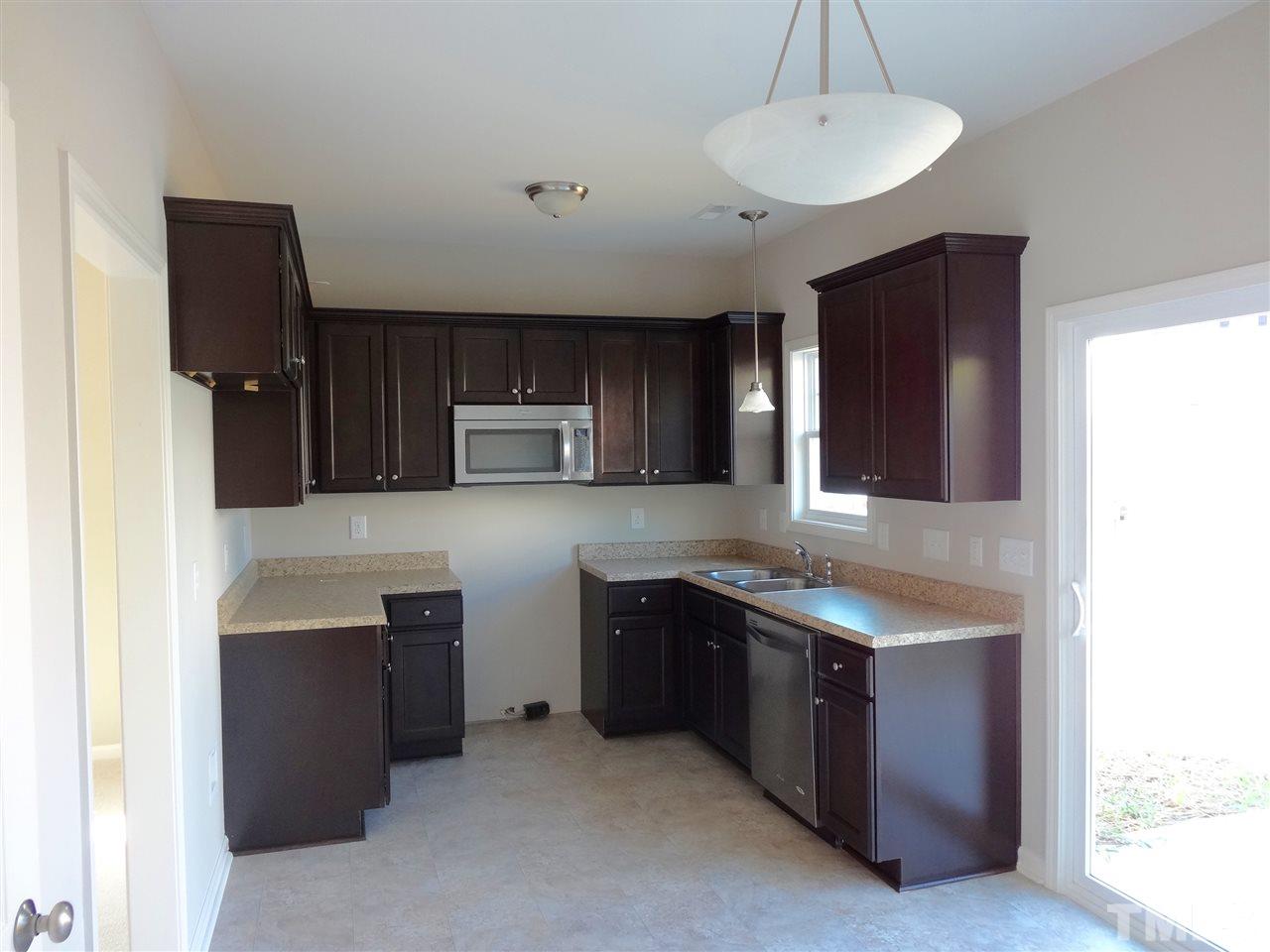 6832 Spanglers Spring Way Raleigh, NC 27610 - Photo 4 of 25 a kitchen with stainless steel appliances granite countertop a sink and a refrigerator