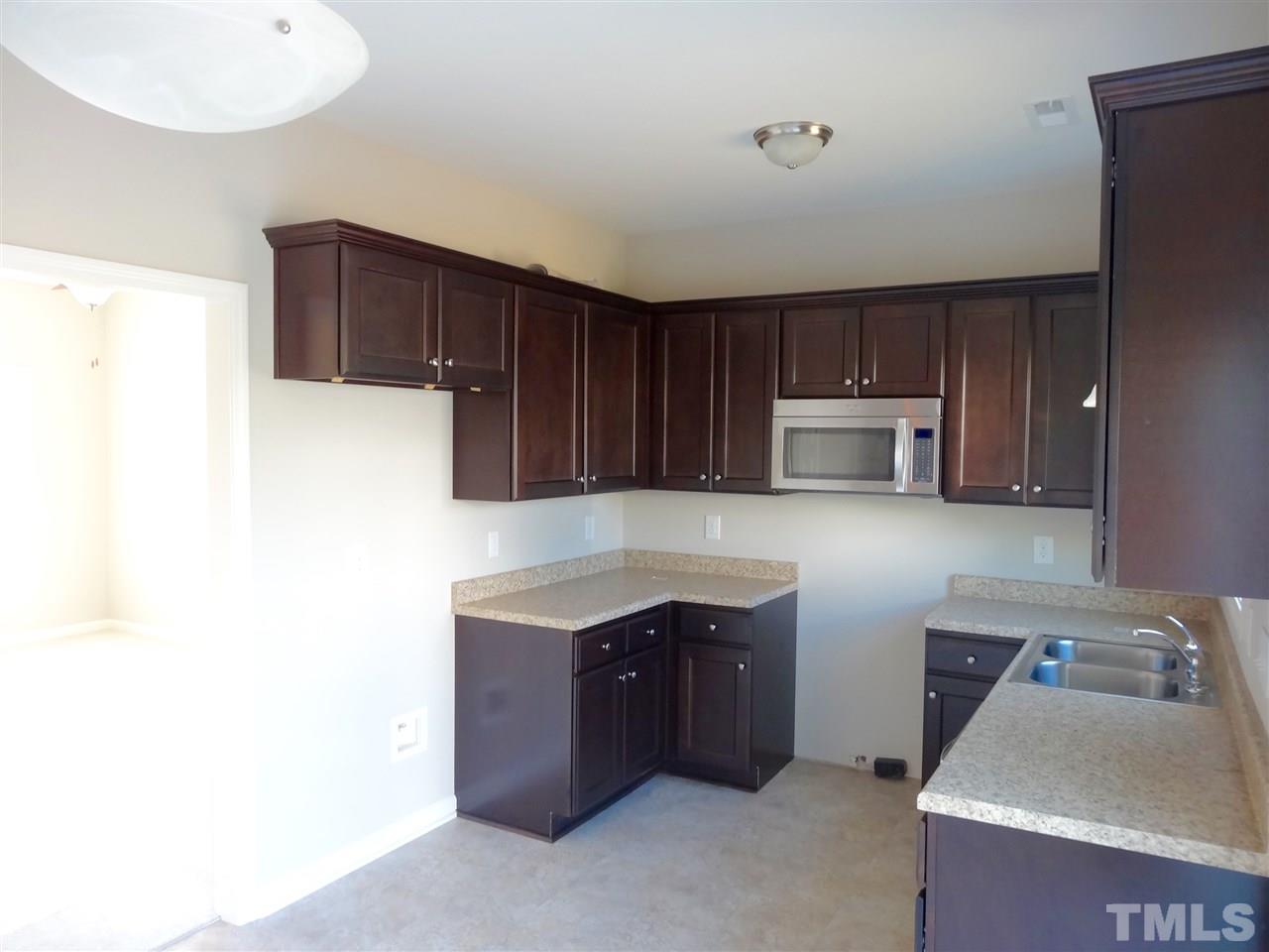 6832 Spanglers Spring Way Raleigh, NC 27610 - Photo 5 of 25 a kitchen with stainless steel appliances a sink a stove a microwave a counter top and cabinets