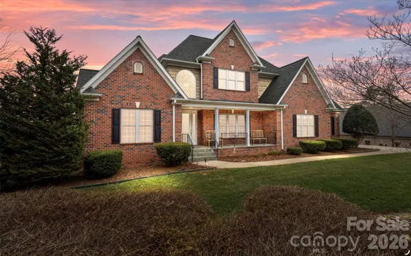 a front view of a house with yard and green space