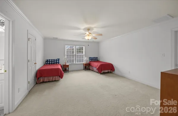 a view of a big room with windows and chandelier fan
