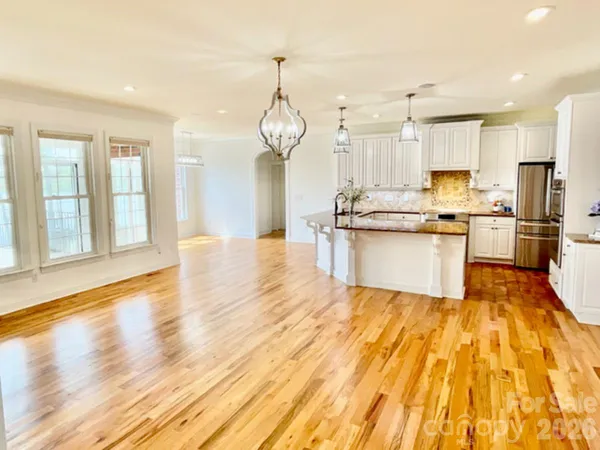 a dining room with furniture a chandelier and wooden floor