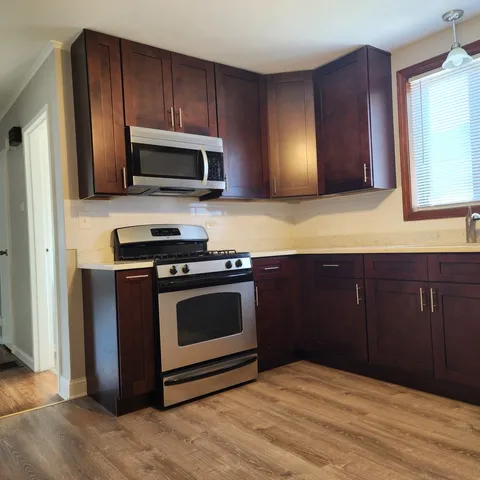 a kitchen with wooden cabinets and stainless steel appliances