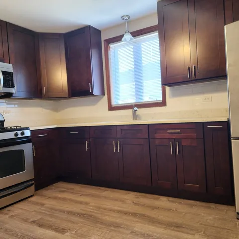 a kitchen with wooden cabinets and a wooden floor