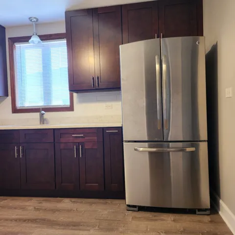 a metallic refrigerator freezer sitting inside of a kitchen