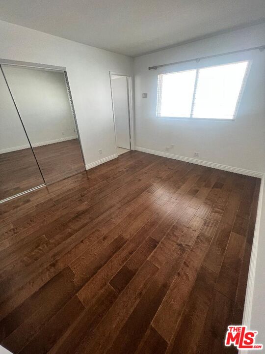 17153 Palisades Circle Pacific Palisades, CA 90272 - Photo 12 of 22 an empty room with wooden floor and windows