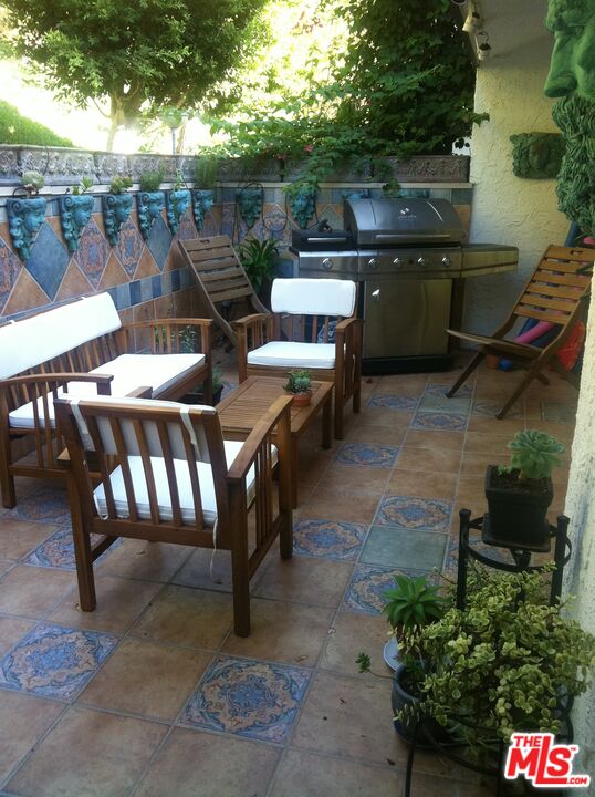 17153 Palisades Circle Pacific Palisades, CA 90272 - Photo 3 of 22 a backyard of a house with table and chairs
