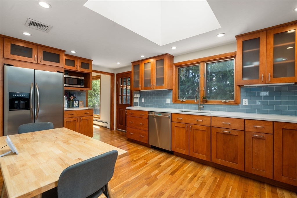 50 Mary Ellen Road Newton, MA 02468 - Photo 3 of 22 a kitchen with stainless steel appliances granite countertop a sink and large wooden cabinets