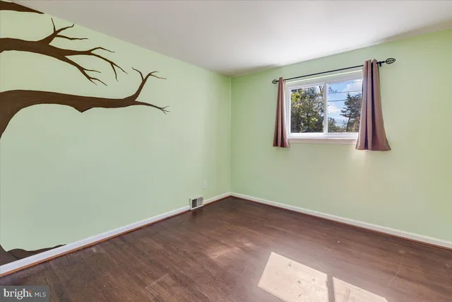 a view of a room with wooden floor and window