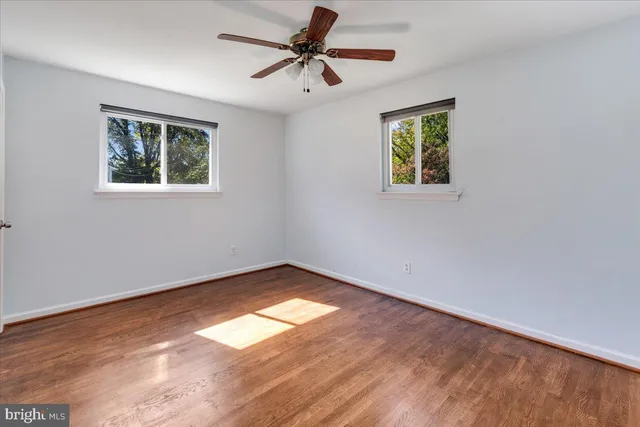 a view of a big room with wooden floor and a window