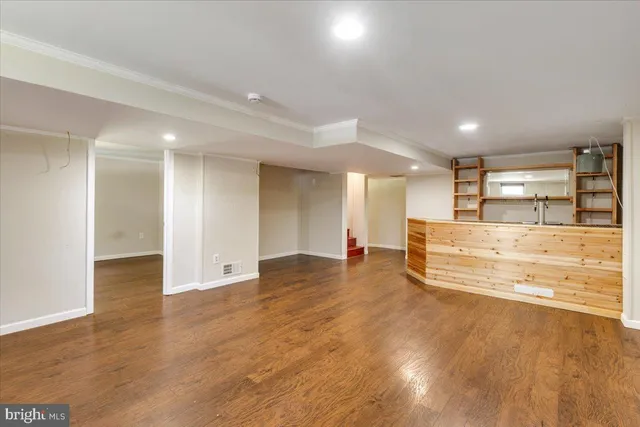 a view of a kitchen with kitchen island a sink stainless steel appliances and cabinets