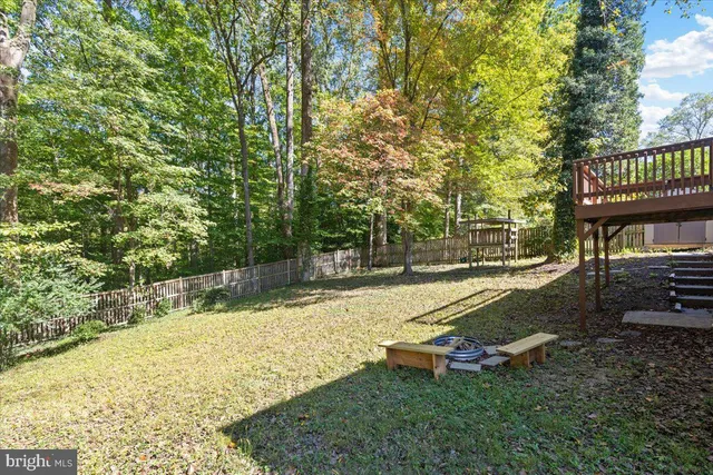 a view of swimming pool with lawn chairs and wooden fence