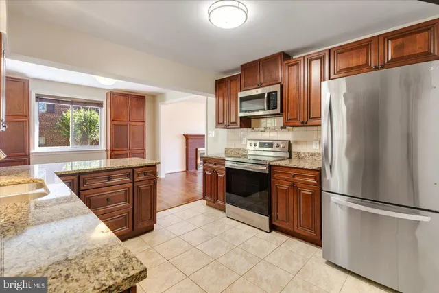 a kitchen with stainless steel appliances granite countertop a refrigerator stove microwave and sink