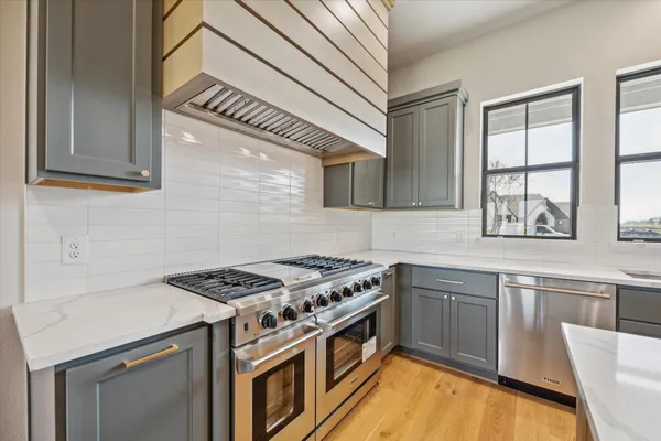 a kitchen with stainless steel appliances granite countertop a stove and a sink
