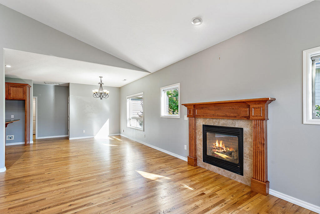 1034 Buck Point Street Central Point, OR 97502 - Photo 18 of 43 a view of an empty room with wooden floor fireplace and a window