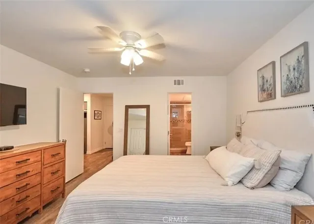 a bedroom with a bed and wooden floor