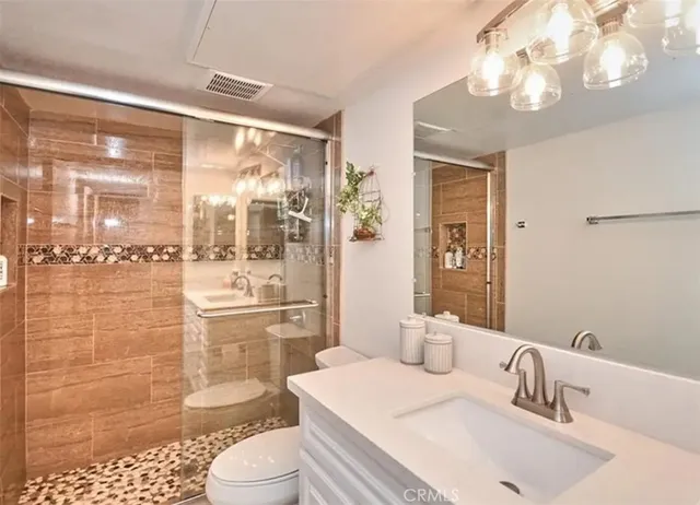 a bathroom with a sink a toilet and shower