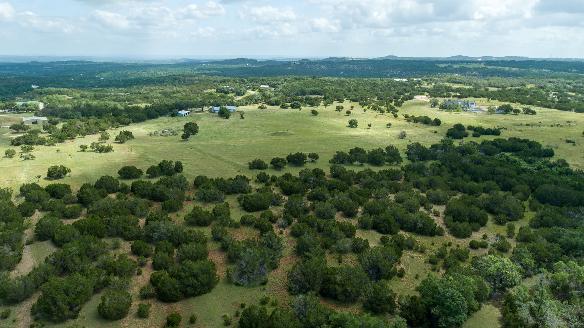 501 Myers Creek Road Dripping Springs, TX 78620 - Photo 29 of 33 Rolling green pastures and dense woodlands stretch across this expansive countryside landscape.