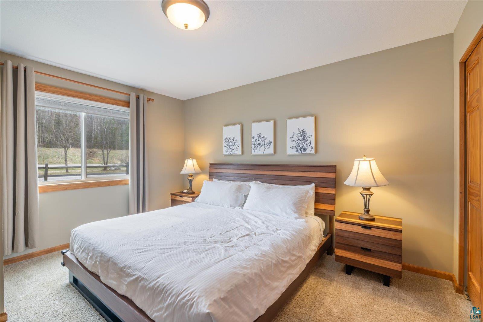 6266 Giants Ridge Road Biwabik, MN 55705 - Photo 22 of 37 Bedroom featuring a window with a wood frame, light-colored walls, and carpet flooring