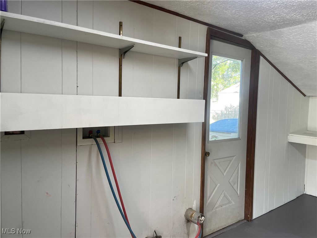 5741 Jaycox Road North Ridgeville, OH 44039 - Photo 18 of 23 Laundry room view of a textured ceiling, concrete floors, and a decorative wall