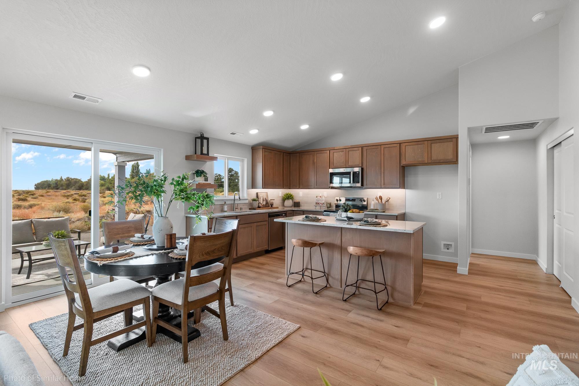 1047 Adamite Road Kimberly, ID 83341 - Photo 2 of 8 Kitchen with brown cabinetry, recessed lighting, light wood-type flooring, lofted ceiling, and a center island