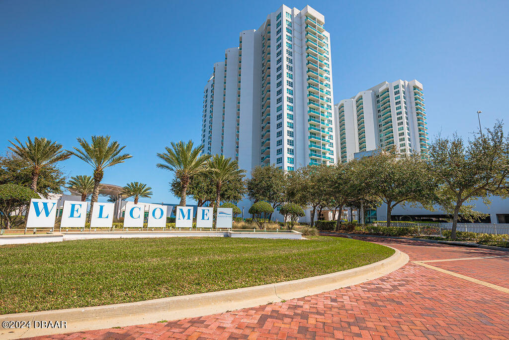 241 Riverside Drive, Unit 2610 Daytona Beach, FL 32117 - Photo 1 of 31 a view of a tall building next to a big yard